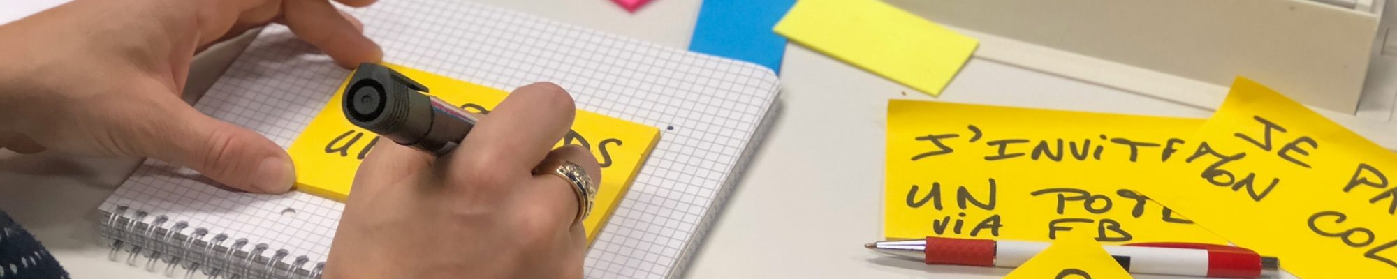 person writing on a sticky note using a marker